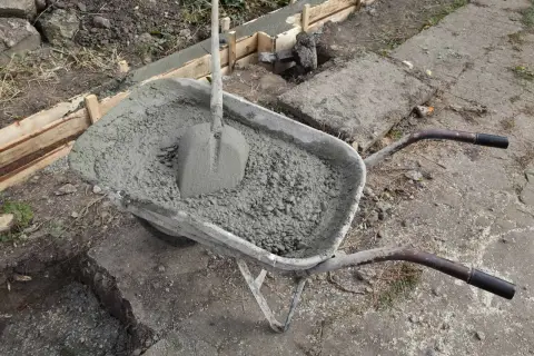 Taczka z betonem i łopatą, gotowa do wykonania zbrojenia ławy fundamentowej 40x60.
